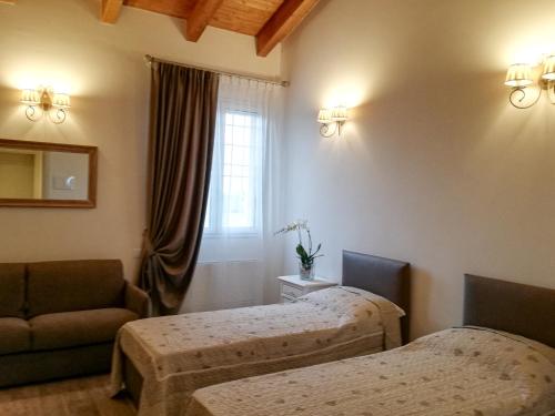 a room with two beds and a couch and a window at Agriturismo N'Uova Campagna in Bologna