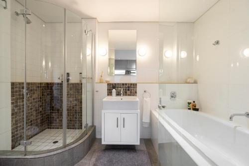 a bathroom with a tub and a sink and a shower at #1803 Cartwright - Simply Spectacular in Cape Town