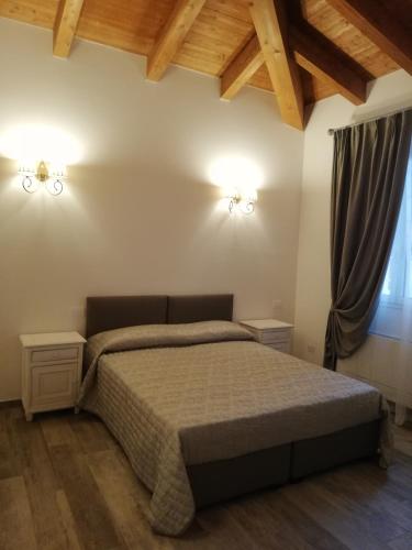 a bedroom with a bed and two lights on the wall at Agriturismo N'Uova Campagna in Bologna