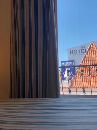 a view of a hotel through a window with curtains at Hospedaria S. Jorge in Fátima
