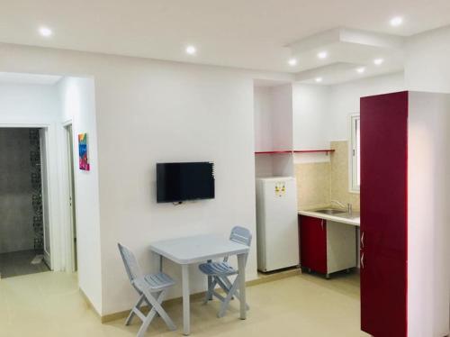 a kitchen with a table and two chairs and a tv at S+1 vue mer climatisé in Chott Meriem