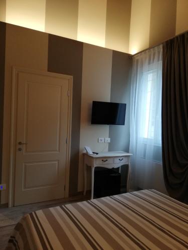 a bedroom with a bed and a desk and a television at Agriturismo N'Uova Campagna in Bologna