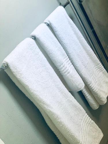 two white towels hanging on a towel rack in a bathroom at Monte Vista in Harrismith