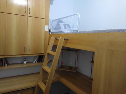 a wooden counter top with a ladder in a kitchen at Aconchegante ao lado do shopping com garagem e Wifi in Teresópolis
