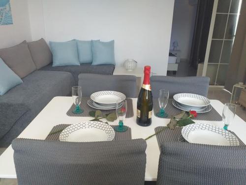 a living room with a table with plates and a bottle of wine at Aegean Blue in Panteli