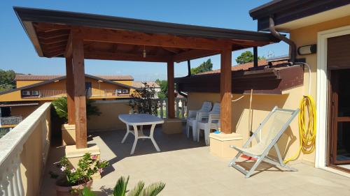 a patio with a wooden pergola and a table and chairs at Don Antonio Residence in Sellia Marina
