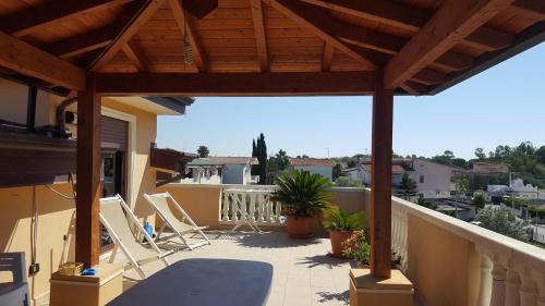 a patio with chairs and a wooden pergola at Don Antonio Residence in Sellia Marina