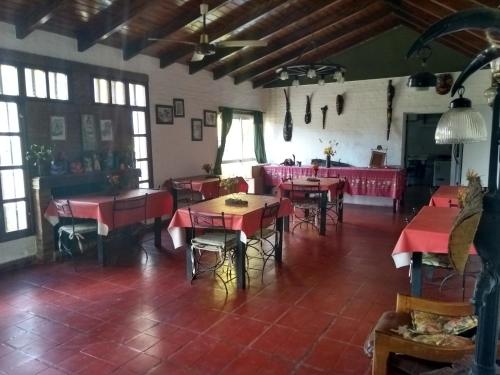 a restaurant with red tables and chairs in a room at Hostería Niemanu in Paso de la Patria