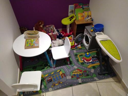 a toy room with a table and chairs and a toy train at Le Roi du Sundgau près de la Horse - Mooslargue in Mooslargue