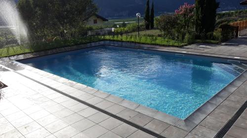 una piscina con acqua blu in un cortile di Hotel Karinhall a Trento