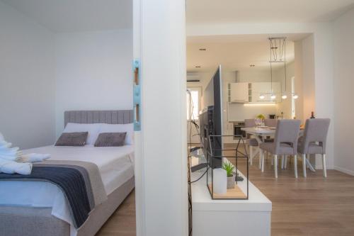 a bedroom with a bed and a dining room at Apartments Capocesto in Primošten