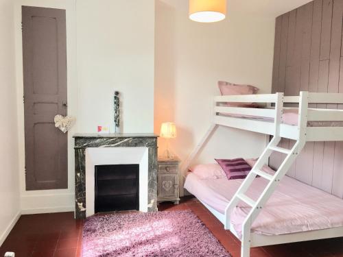 a bedroom with a bunk bed and a fireplace at Maison de ville jardin 2km de Tours in Saint-Pierre-des-Corps