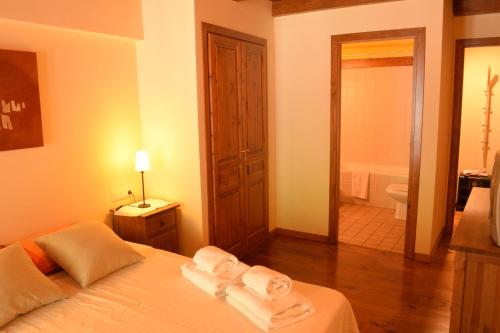 a bedroom with a bed and a bathroom with a tub at Apartamento Forcanada in Las Bordas