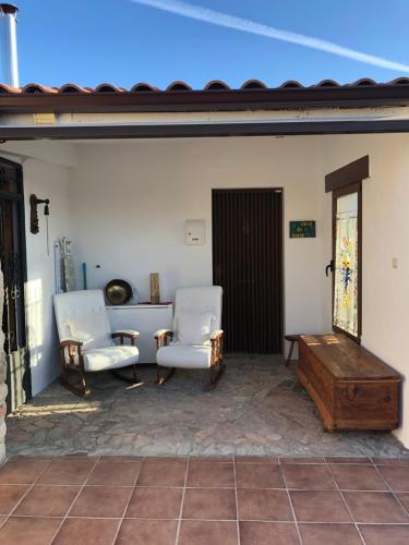 a patio with two chairs and a wooden table at Casa Rural "Rincón del Edén" in Tardobispo