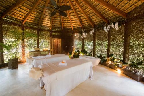una grande stanza con tavoli bianchi e un soffitto di Sublime Samana a Las Terrenas