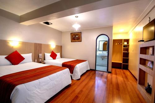 una camera d'albergo con due letti e una finestra di Royal Inka II a Cuzco