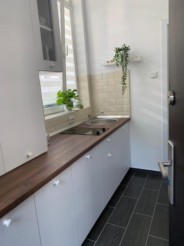 a kitchen with white cabinets and a sink at Maison 33 in Bucharest
