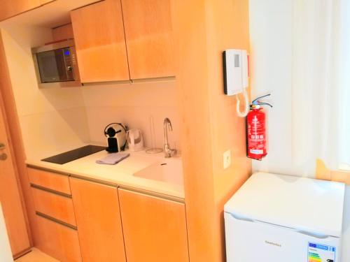 a small kitchen with a sink and a refrigerator at Apartamento Praia do Relógio in Figueira da Foz