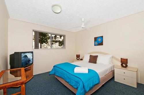 a bedroom with a bed and a tv at Champelli Palms Apartments in Gold Coast