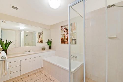 a bathroom with a shower and a sink at Champelli Palms Apartments in Gold Coast