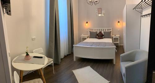 a small bedroom with a bed and a chair at Maison 33 in Bucharest