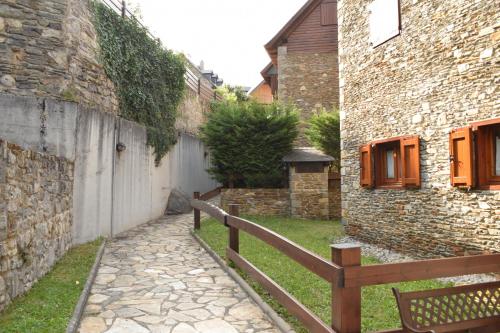 an alley between two buildings with a wooden fence at Apartamento Forcanada in Las Bordas