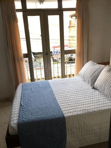 a bedroom with a bed and a large window at Hotel Armont in Calarcá