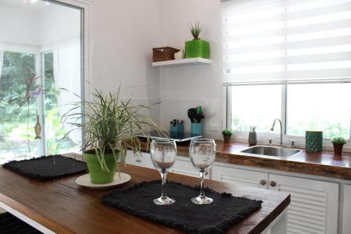 two wine glasses sitting on a counter in a kitchen at Ojochal Gardens in Ojochal