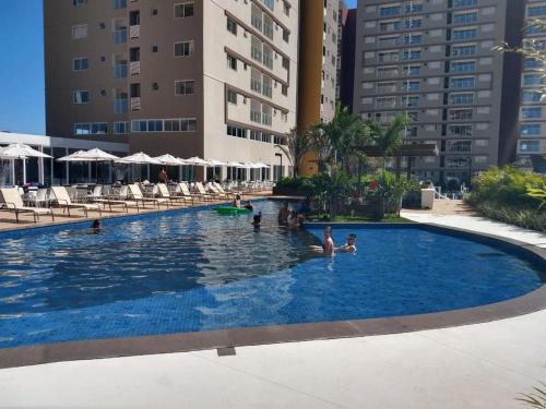 een groot zwembad met mensen in het water bij EVIAN THERMAS RESIDENCE in Caldas Novas