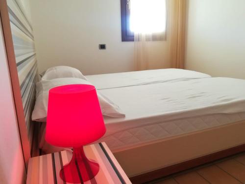 a red lamp sitting on a table next to a bed at Luxury Villa Duna Verde in Duna Verde