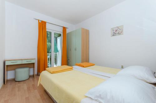 a bedroom with two beds and a window at Apartments Marjan in Brna