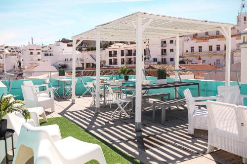 a patio with a table and chairs on a roof at Peneco Albufeira GuestHouse in Albufeira