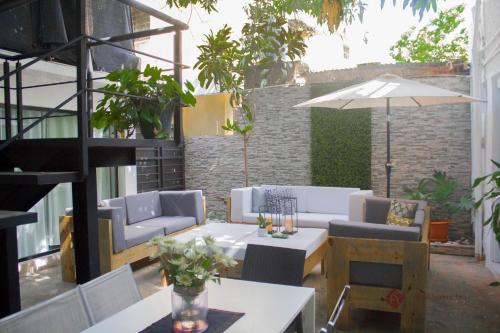 a patio with a table and chairs and an umbrella at Hotel Santa Clara in San Fernando de Monte Cristi