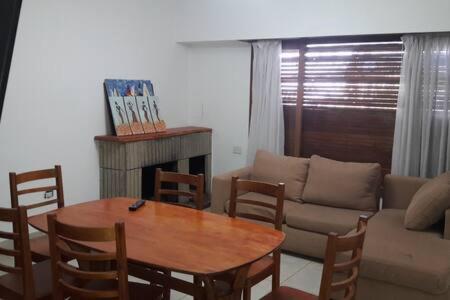 a living room with a table and a couch at Departamento centrico y amplio, 6 personas, NQN. in Neuquén