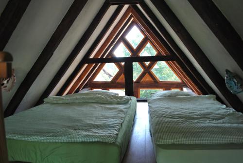 two beds in a room with a large window at Maison Pittoresque in Hermerswiller