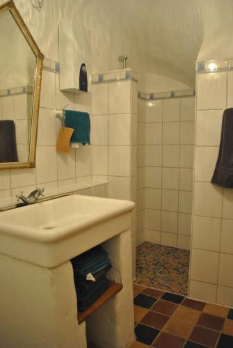 a white bathroom with a sink and a shower at Maison Pittoresque in Hermerswiller