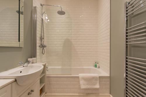 a white bathroom with a tub and a sink at Beautiful Property In A Fantastic Location in St Andrews