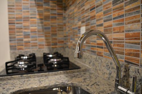 un bancone da cucina con fornelli e lavello di Lofts Asa Delta apartamento com cozinha a Ilhabela