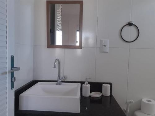 a white bathroom with a sink and a mirror at Cantinho da Gê-"Sinta-se a vontade!"-Maragogi in Maragogi