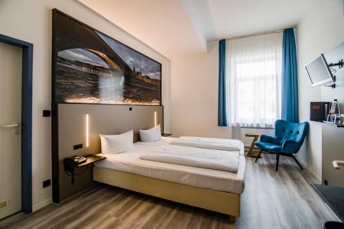 
a hotel room with a bed, desk and a painting on the wall at Hotel Weidenhof in Regensburg
