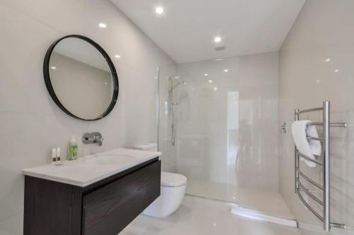 a bathroom with a sink and a shower and a mirror at Executive Living in Bluewater - 3 Bedroom Apartment in Queenstown