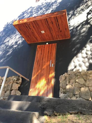 a wooden door on the side of a building with stairs at Winter Suites Campos do Jordão - Capivari in Campos do Jordão