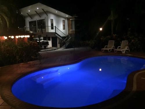a blue pool in front of a house at night at Villas Luna de Miel in Carmen