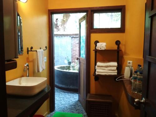 a bathroom with a sink and a bath tub at The Country House in Senggigi 