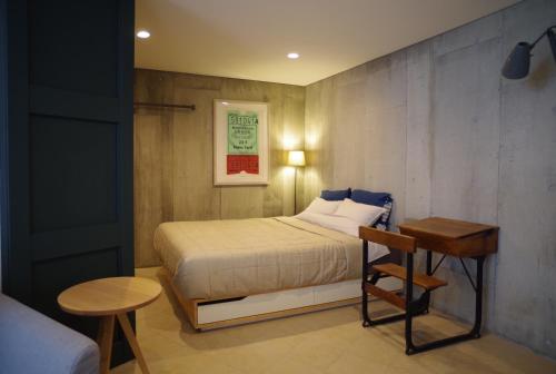 a small bedroom with a bed and a table at Sango Katase Guest Rooms in Fujisawa