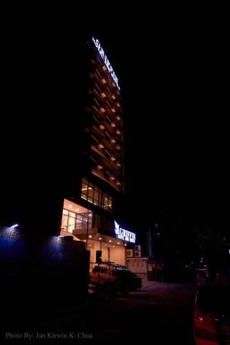 a tall building with a sign on it at night at Griffin Hotel and Suites in Cebu City