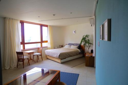 藤沢市にあるSango Katase Guest Roomsのベッドルーム1室(ベッド1台、テーブル、椅子付)
