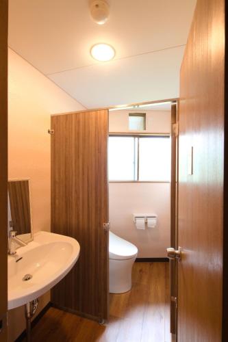 a bathroom with a toilet and a sink at Onsen & Garden -Asante Inn- in Hakone