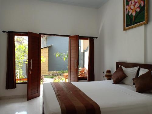 a bedroom with a bed and a large window at Dwiki Putra Home Stay in Nusa Lembongan