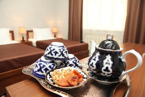 - une table avec une théière et une assiette de nourriture dans l'établissement Hotel Vardonze, à Boukhara